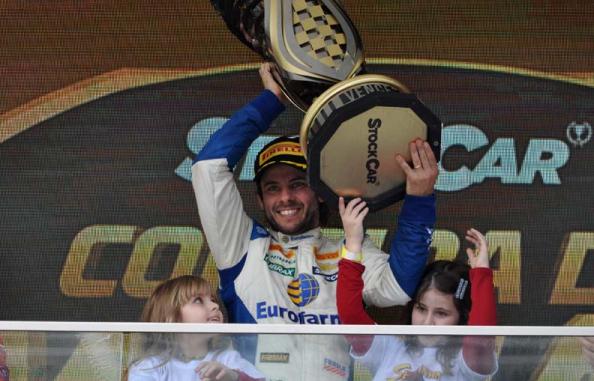 Vencedor de 40 anos exibe o trofeu entre as filhas