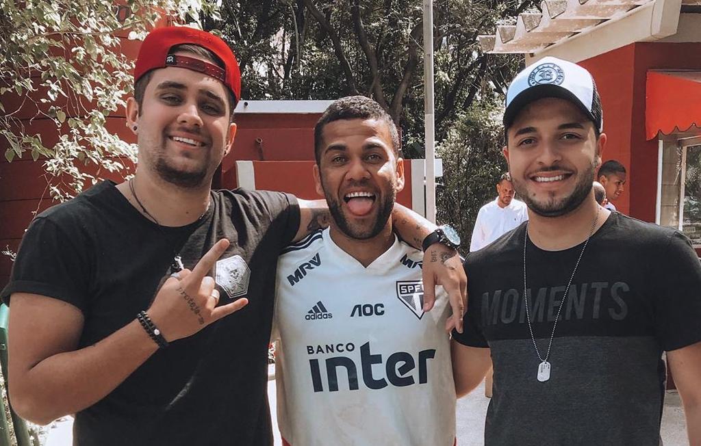 Após jogo, Daniel Alves sobe em palco de show de amigos sertanejos