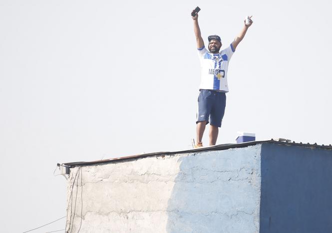 Torcida improvisa arquibancada na laje para assistir jogo do Água Santa