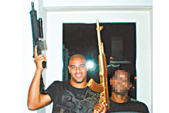 Adriano ao lado de traficante com fuzil na mão