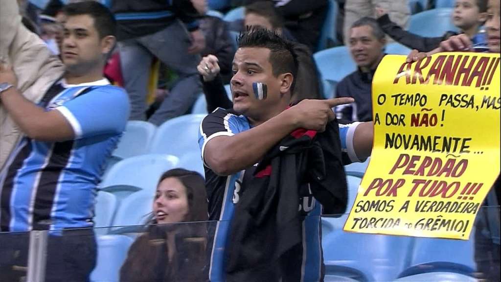 Torcedor levou cartaz para se desculpar por episódios racistas na Arena do Grêmio. (Foto: Reprodução / Premiere)