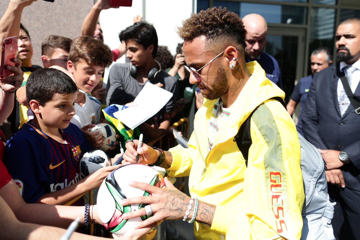 Neymar distribui autógrafos na chegada e se apresenta à seleção brasileira