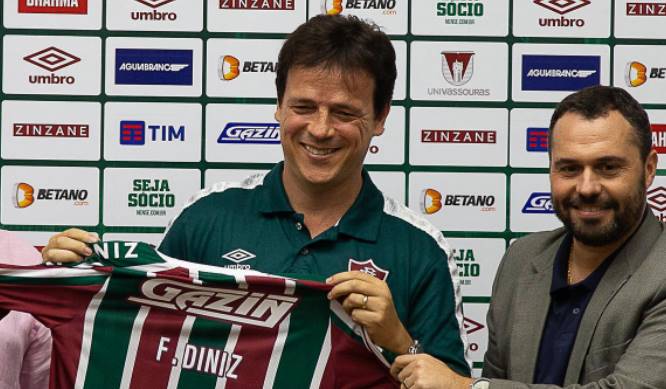 fernando diniz segurando camisa do Fluminense