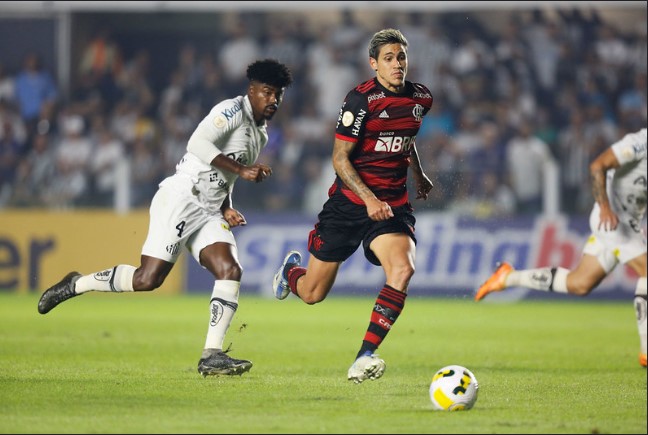 Antes da decisão pelo título da Libertadores, o Flamengo tem um compromisso pelo Campeonato Brasileiro. Nesta terça-feira (25), os cariocas recebem o Santos no Maracanã, em partida válida pela 34ª rodada da competição. O rubro-negro ocupa a terceira posição do Brasileirão, com 58 pontos, mas já sem chances de alcançar o líder Palmeiras e brigar pelo título. O Peixe, e 12º, com 43, ainda sonha em beliscar uma vaga para a Liberta de 2023. FLAMENGO O Flamengo quer vencer para chegar com moral na finalíssima de sábado (29), diante do Ahtletico-PR. Para isso, Dorival Júnior já afirmou que irá entrar em campo com time misto para enfrentar o Santos nesta terça-feira (25). Pensando em preservar atletas importantes e ainda dar rodagem ao elenco do Flamengo, o técnico rubro-negro deve iniciar a partida com quatro ou cinco jogadores titulares. O objetivo é que, mesmo poupados, mantenham o ritmo. No treino desta segunda-feira (24), Santos, David Luiz, Everton Ribeiro e Pedro foram os selecionados para esboçar o possível time que entrará em campo contra o Time da Vila. Filipe Luís também treinou, mas ainda será reavaliado sobre possíveis riscos de lesão. Assim como Gabigol, que está gripado, mas participou dos trabalhos no CT. Ambos já afirmaram que querem jogar na terça-feira (25). O Flamengo não terá à disposição o volante Arturo Vidal e nem o lateral-direito Guilherme Varela, ambos lesionados. O chileno sentiu dores no tornozelo na partida contra o Corinthians, pela final da Copa do Brasil, e precisou realizar procedimento de drenagem de líquidos. Ele ainda tem chances de se recuperar a tempo da final da Libertadores. O lateral, por outro lado, sofreu uma lesão muscular na coxa e não deve ter condições físicas para reforçar o time no fim de semana. Thiago Maia também segue no departamento médico em tratamento intensivo para se recuperar a tempo da decisão do continental no sábado (29). SANTOS Vindo de uma derrota no clássico contra o Corinthians, o Santos terá alguns problemas para enfrentar o Flamengo no Maracanã, especialmente no setor defensivo. O lateral-direito Madson, que apresentou uma fadiga muscular no último sábado (22), treinou normalmente nesta segunda-feira (24) no CT Rei Pelé. O mesmo vale para o zagueiro Bauermann, que deve ser relacionado para enfrentar o Flamengo. Maicon, outra peça defensiva do Peixe, realiza transição física após uma lesão muscular na coxa direita mas não participou do treino com o restante do grupo. Como se já não bastasse, Luiz Felipe teve um edema muscular constatado na coxa direita e se tornou mais uma baixa na zaga santista. No meio campo, mais dois desfalques certos: Lucas Barbosa e Lucas Braga. O meio-campista foi expulso na partida contra o Corinthians e está suspenso, assim como o atacante, que recebeu o terceiro cartão amarelo no clássico alvinegro. Soteldo, com uma lesão na coxa direita, segue fora das opções de Orlando Ribeiro.